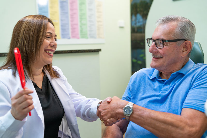 Doctor holding up mirror shaking Patients hand