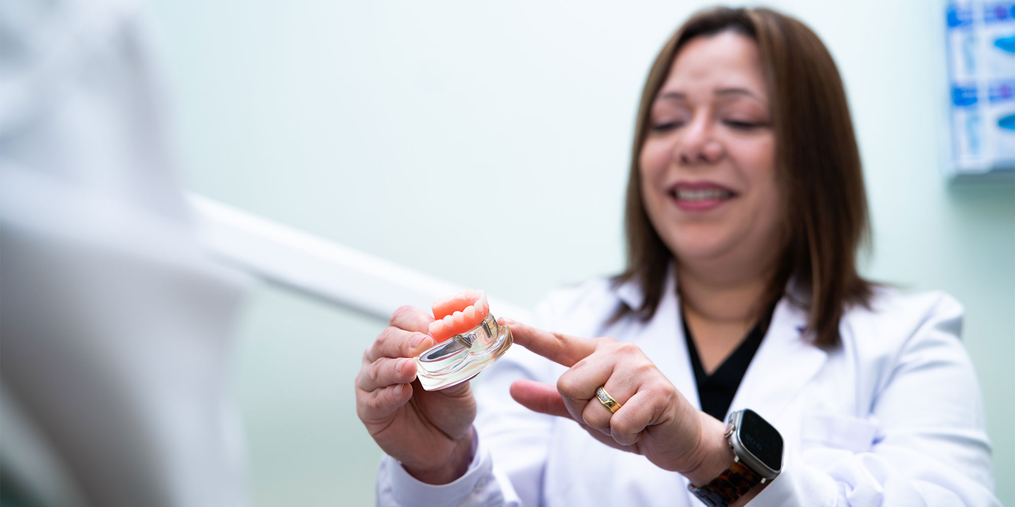 Doctor holding a model full arch implants