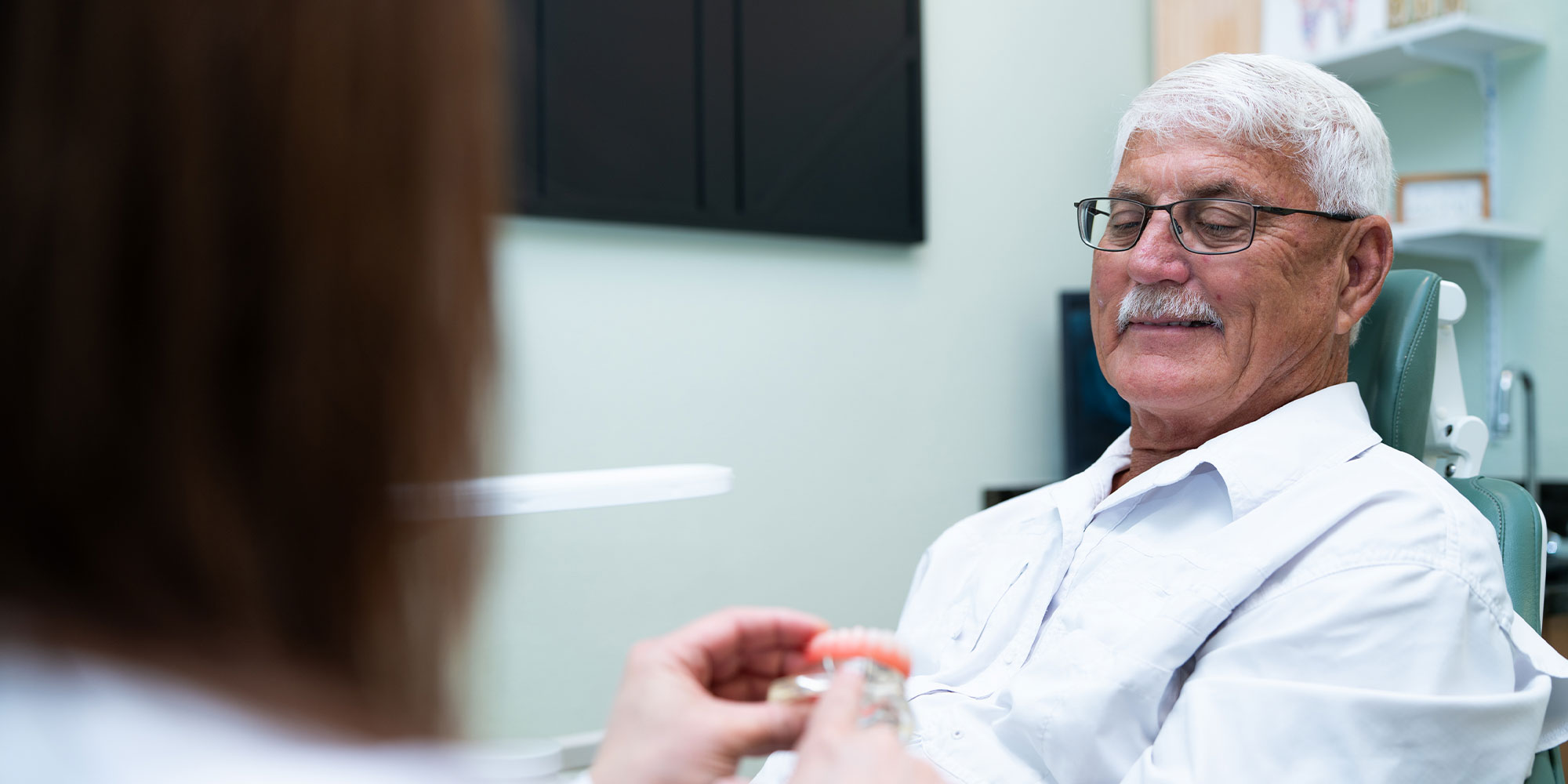 Patient holding a model of full arch implants